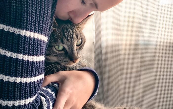 A woman hugs her beloved tabby cat. Image is for illustrative purposes only. Photo by Remy Gieling on Unsplash